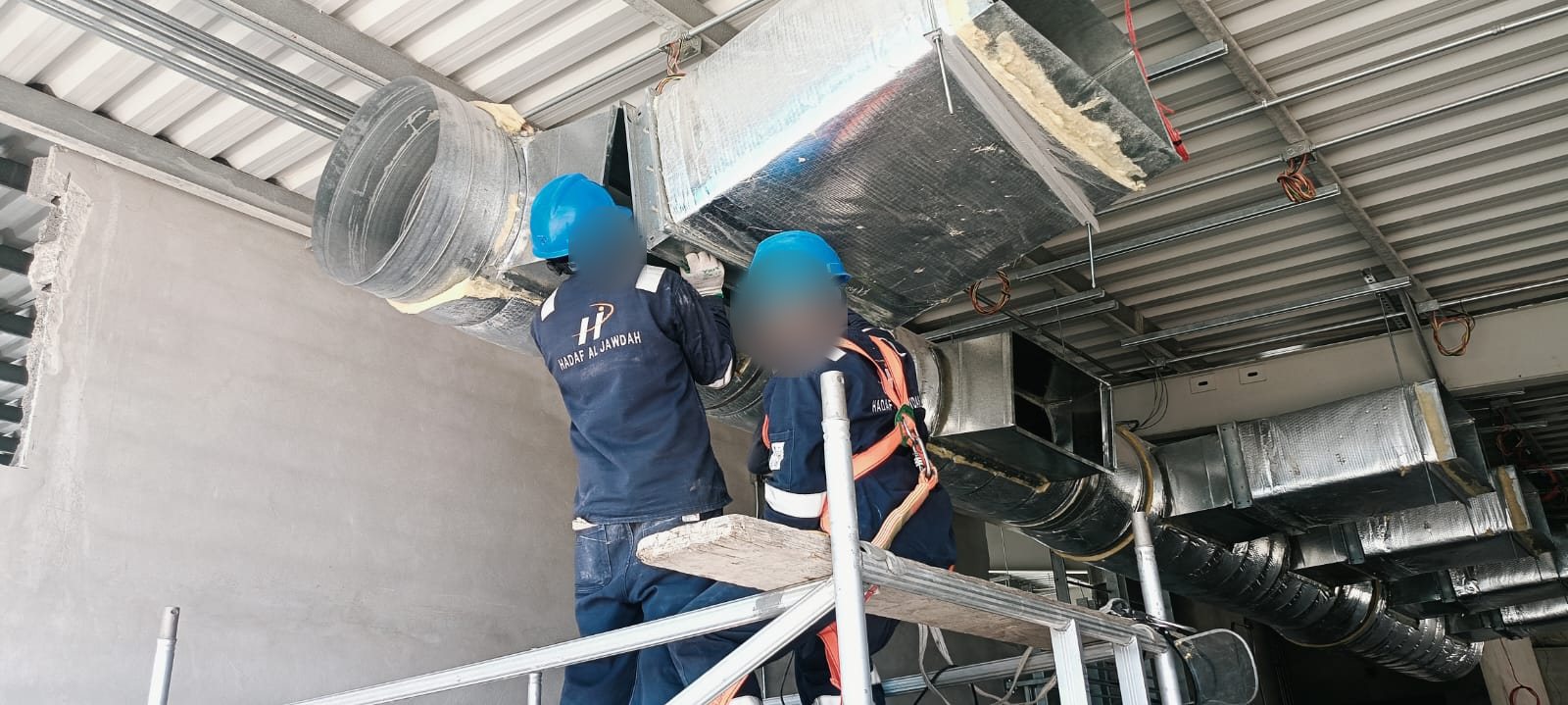 Hadaf team installing ductwork on site